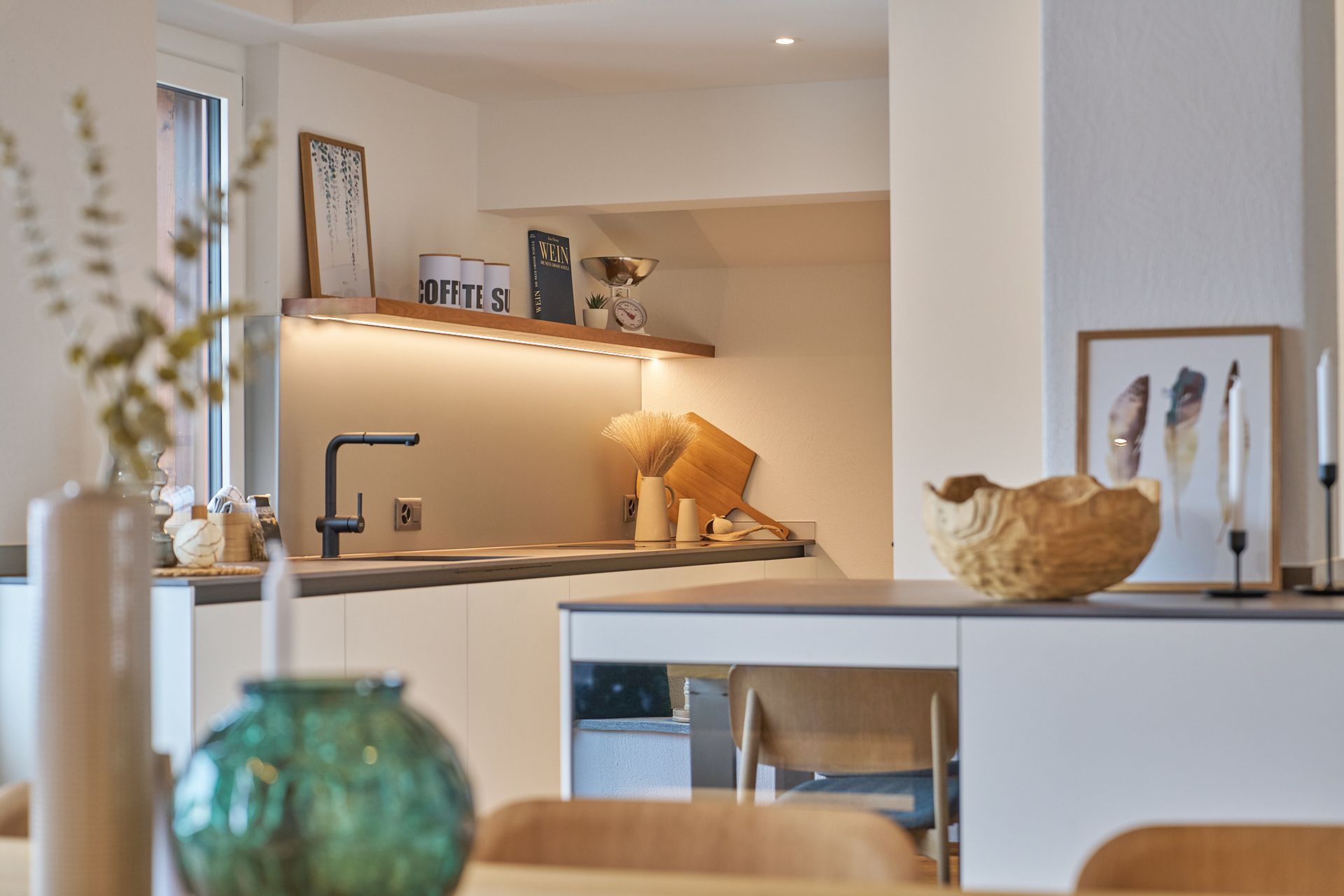 Eine Küche mit einer Spüle und einem Tisch mit einer Blumenvase darauf.