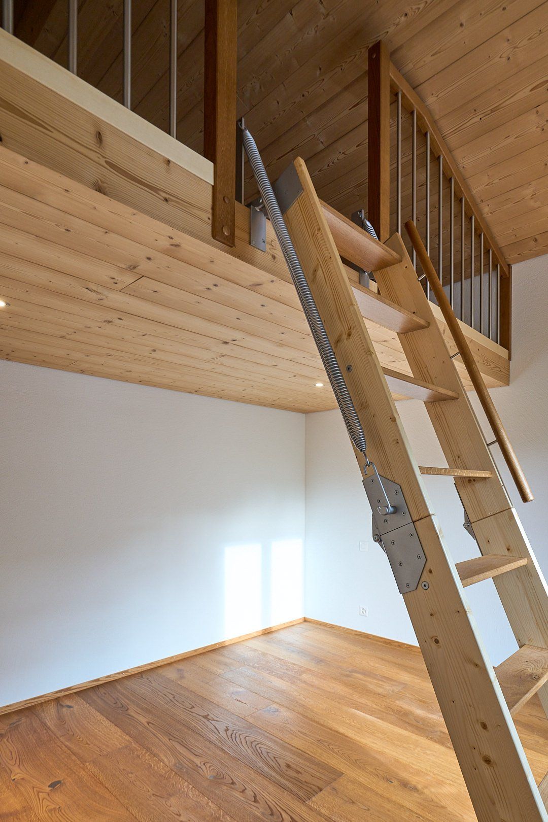 Ein leerer Raum mit einer Holzleiter, die in den zweiten Stock führt
