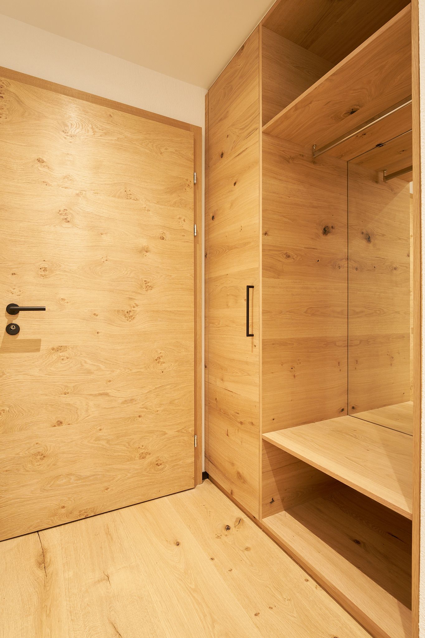 ein Flur mit einer Holztür und einem Holzschrank.