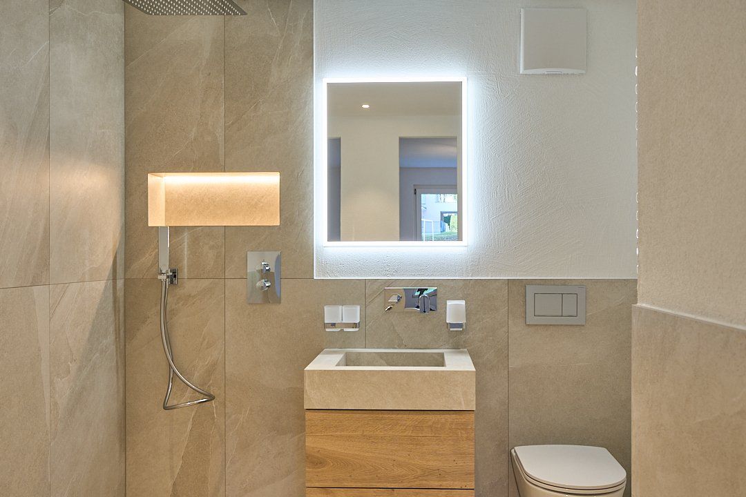 Ein Badezimmer mit Toilette, Waschbecken und Spiegel