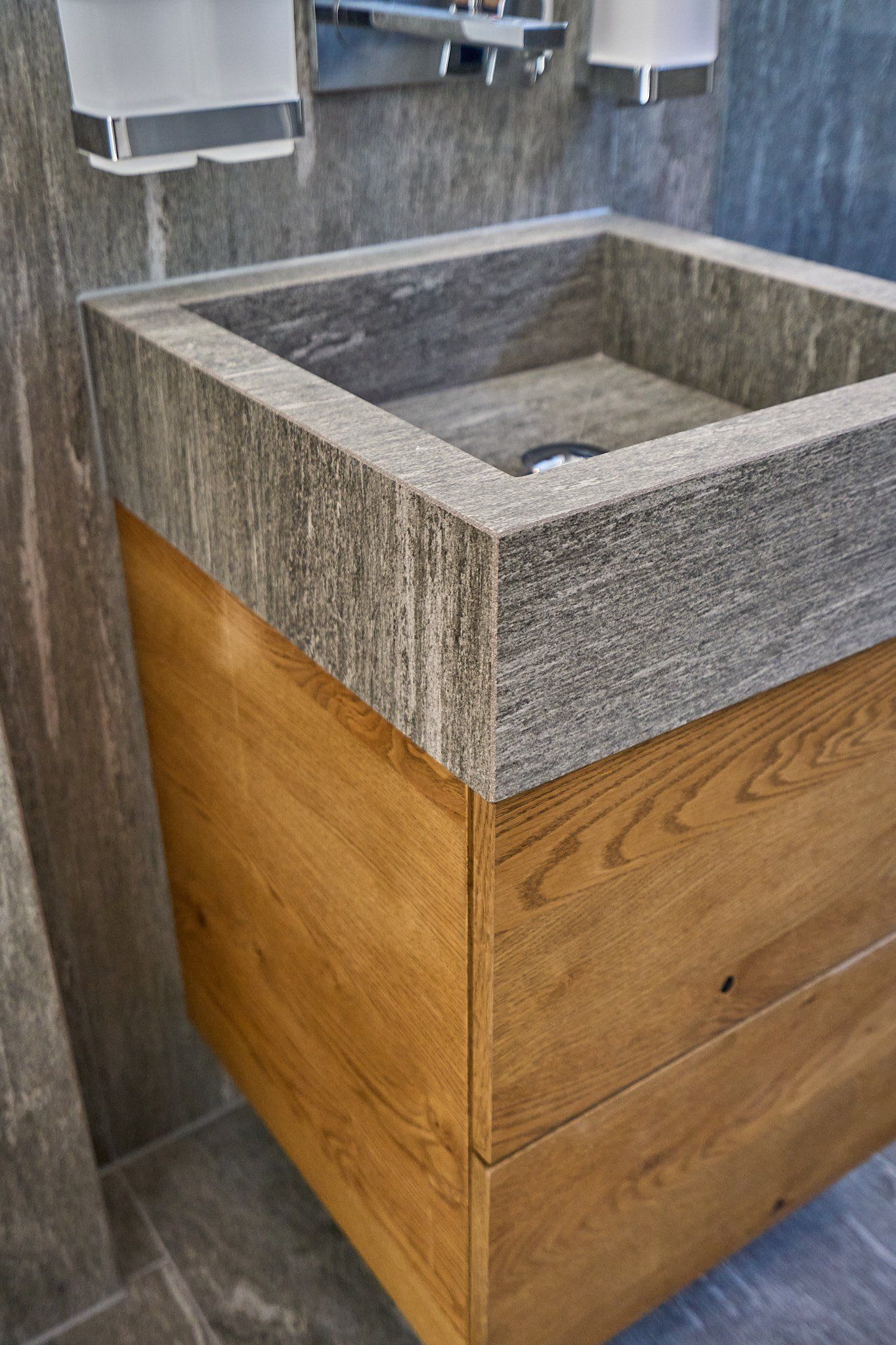 Ein Waschbecken im Badezimmer mit einem Holzschrank darunter.