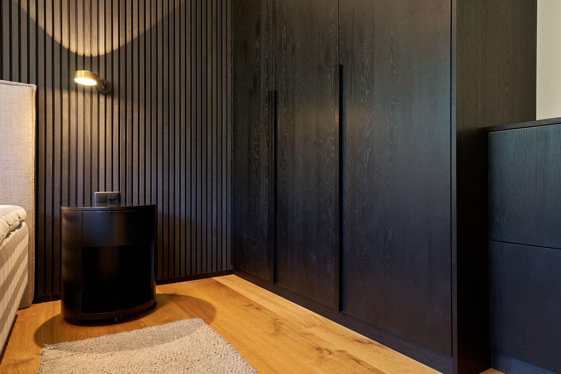 Ein Schlafzimmer mit Bett, Nachttisch, Kommode und Kleiderschrank.