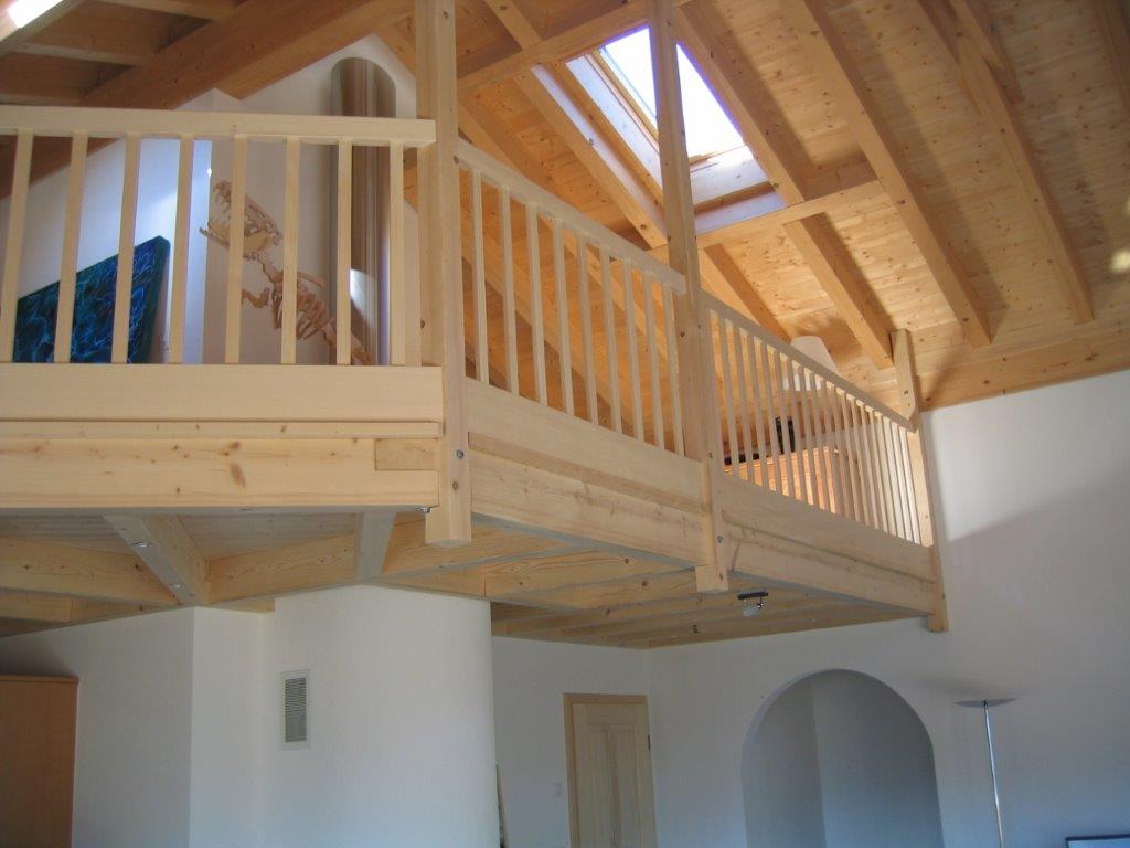 Ein Balkon mit einem Holzgeländer in einem Haus