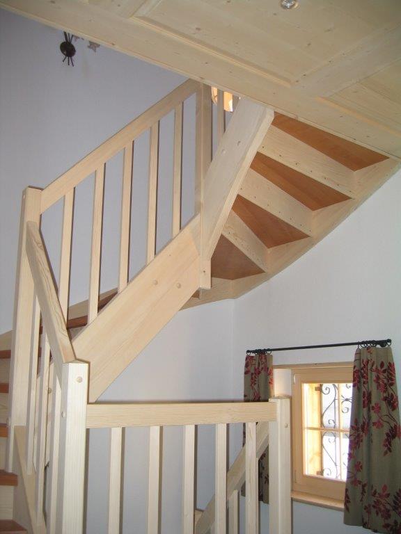 Eine hölzerne Wendeltreppe in einem Raum mit einem Fenster
