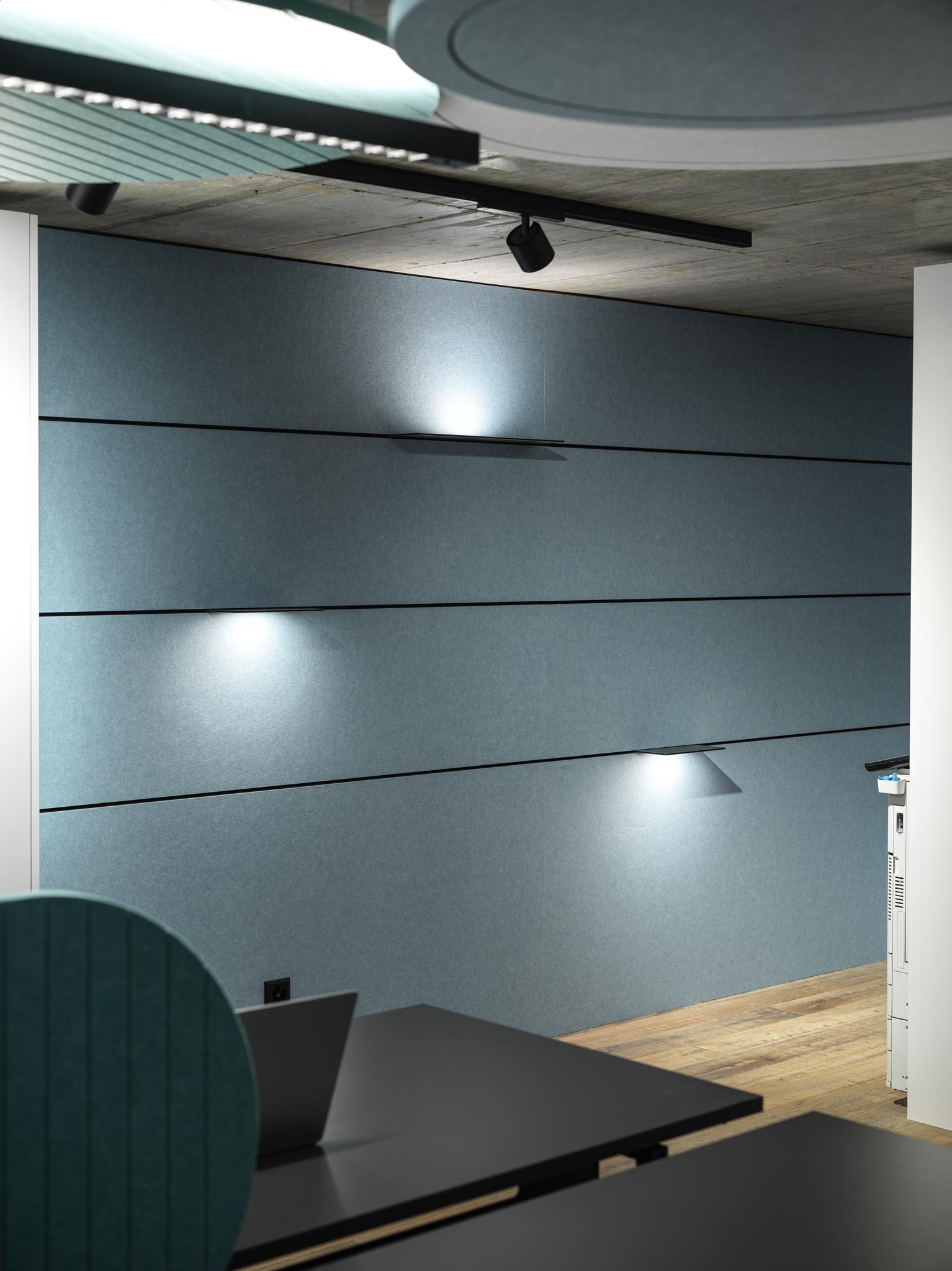 Ein Raum mit einer blauen Wand und einem Schreibtisch mit einem Laptop darauf