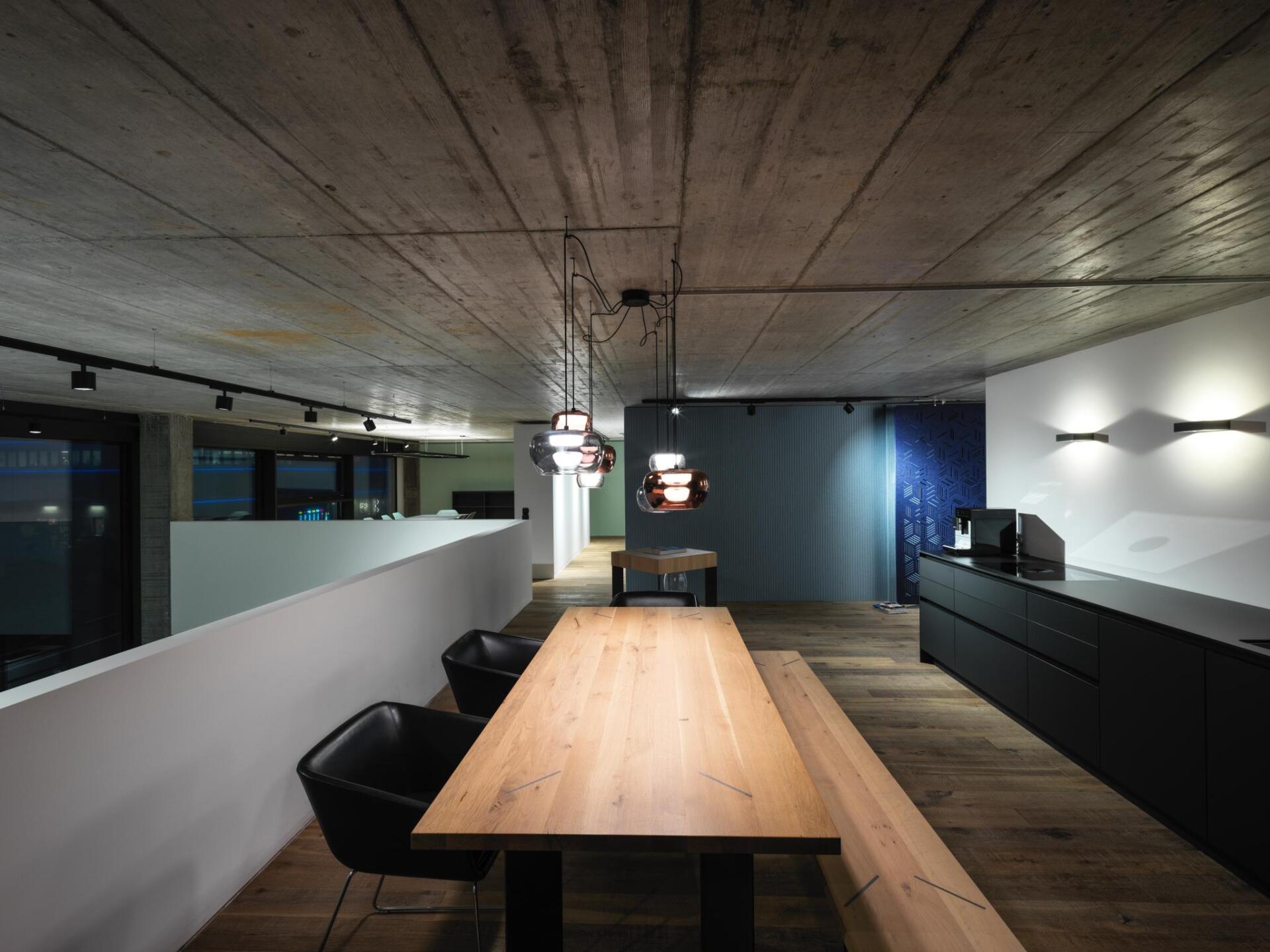 Ein Esszimmer mit einem Holztisch und schwarzen Stühlen