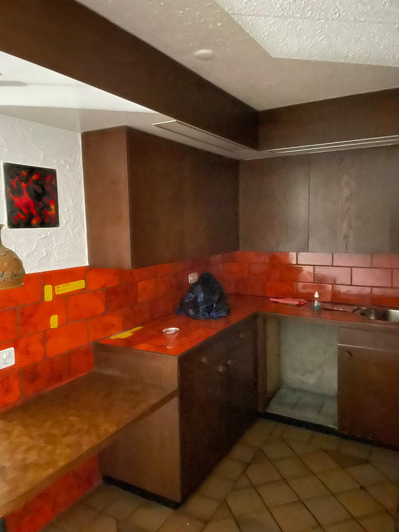 Eine Küche mit roten Backsteinwänden und braunen Schränken