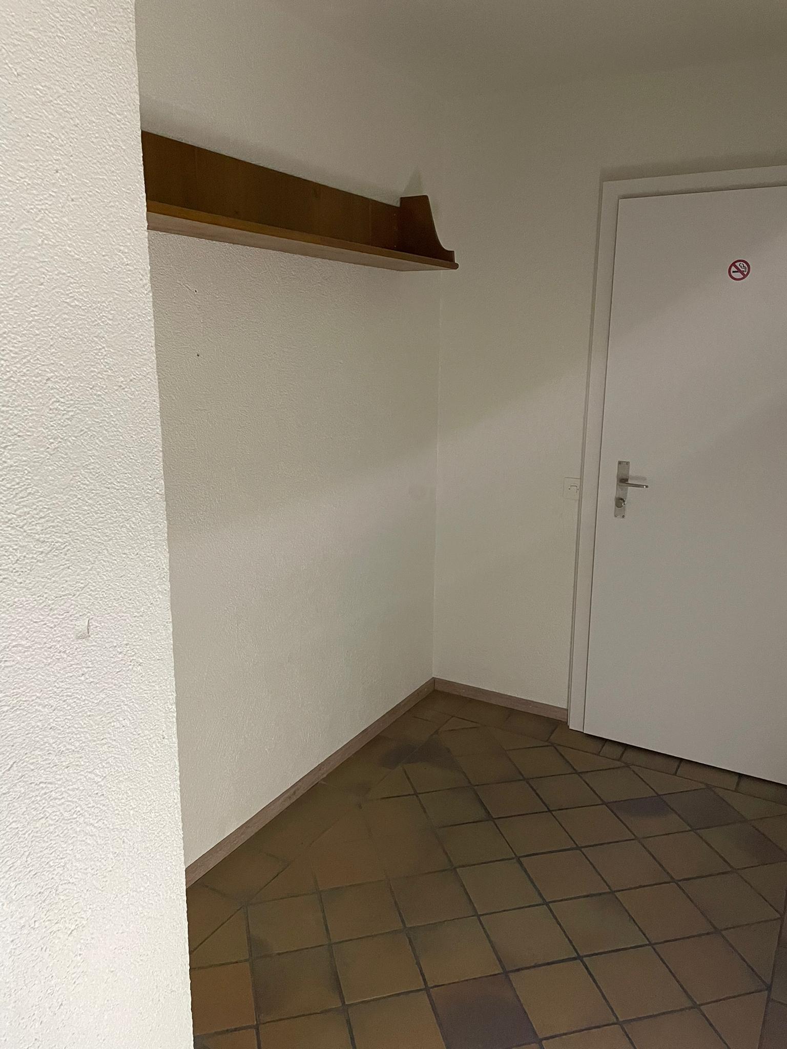 Eine Zimmerecke mit einer Tür und einem Regal.