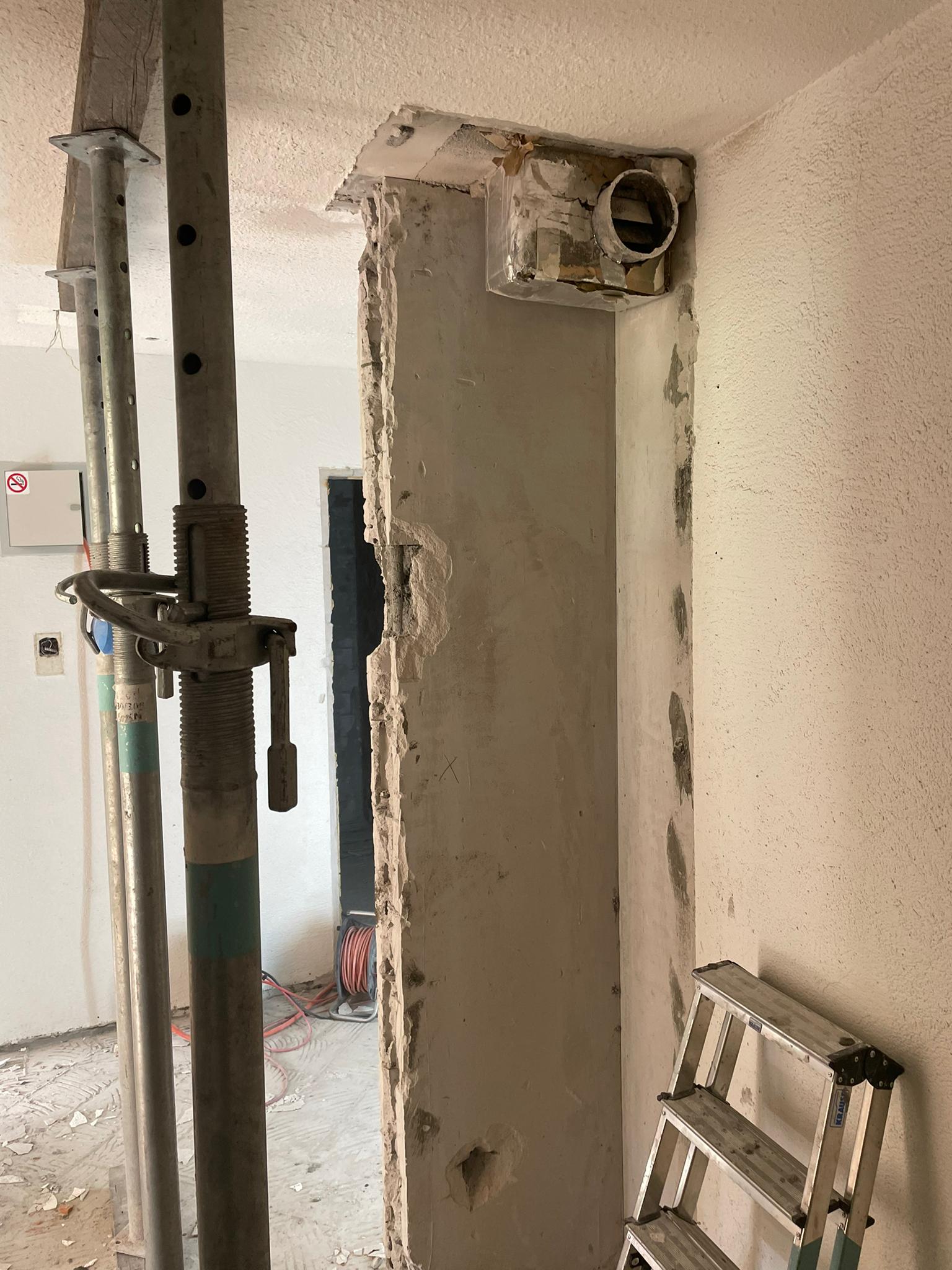 In einem Raum im Bau lehnt eine Leiter an einer Wand.