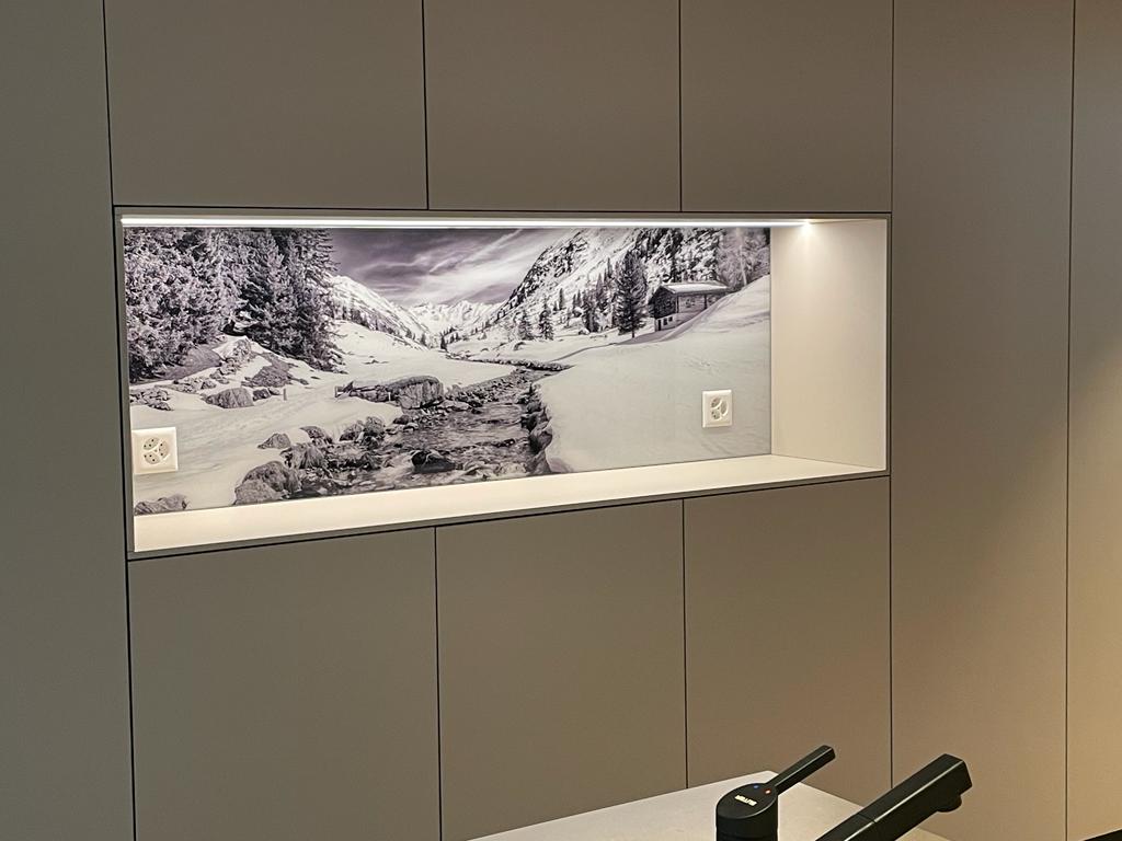 Eine Küche mit einem Bild eines schneebedeckten Berges an der Wand.