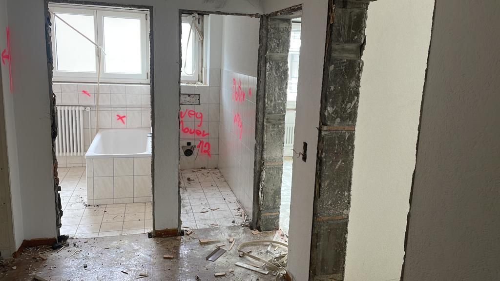 Ein leerer Raum mit einer Badewanne und einem Fenster