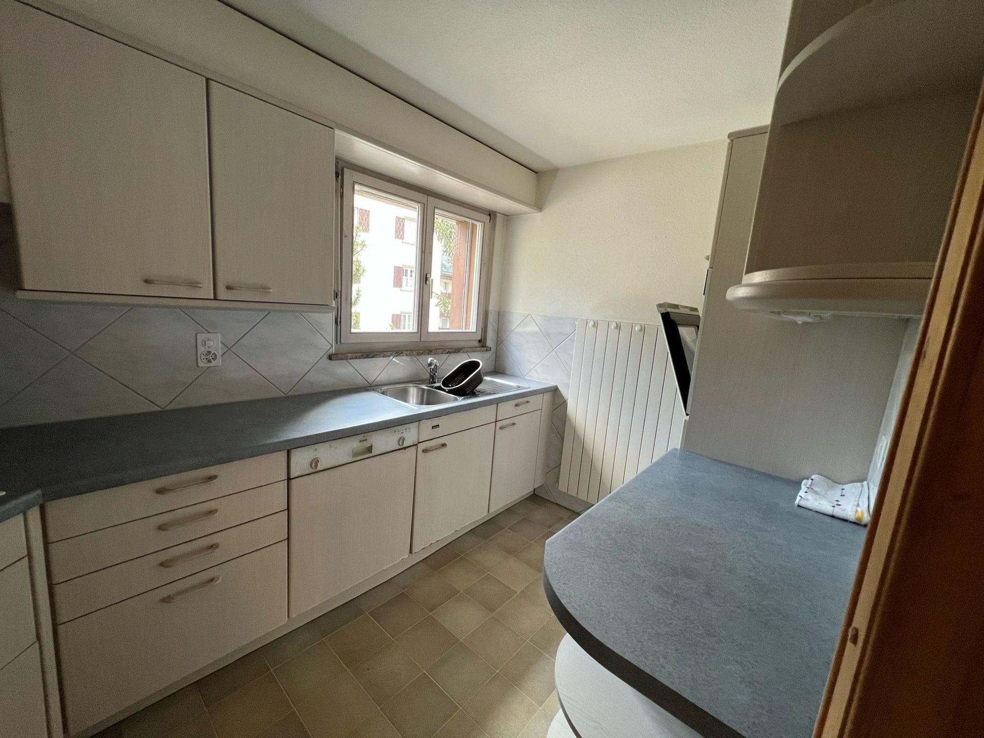 Eine Küche mit weißen Schränken und einem Fenster