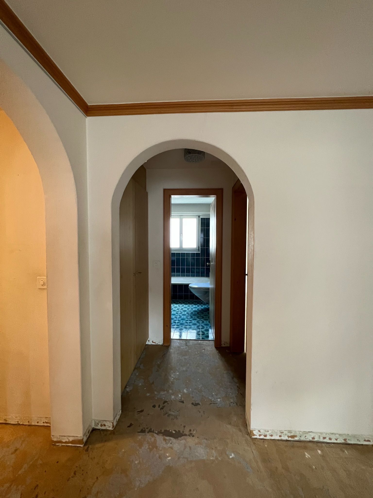 Ein leerer Flur mit Bögen und einer Tür