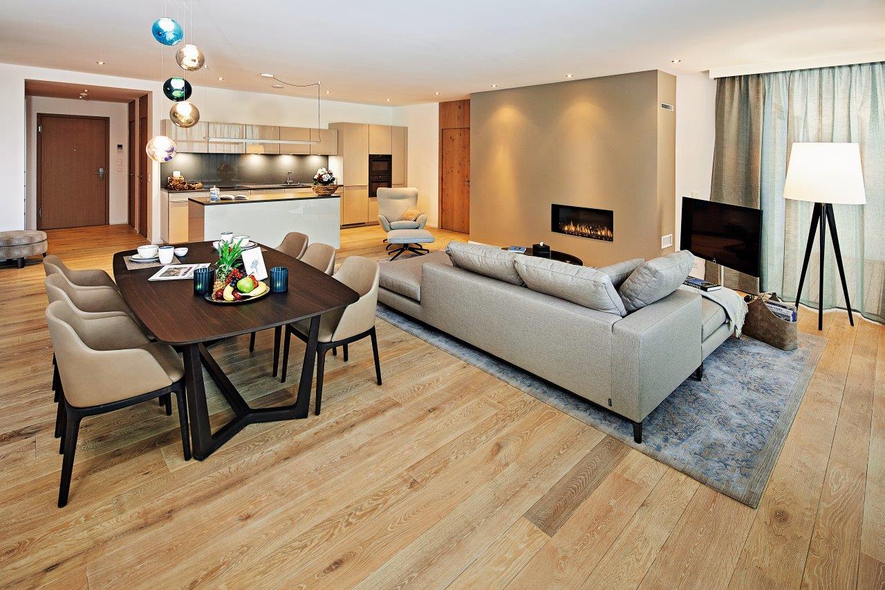 Ein Wohnzimmer mit Couch, Tisch, Stühlen und Kamin.