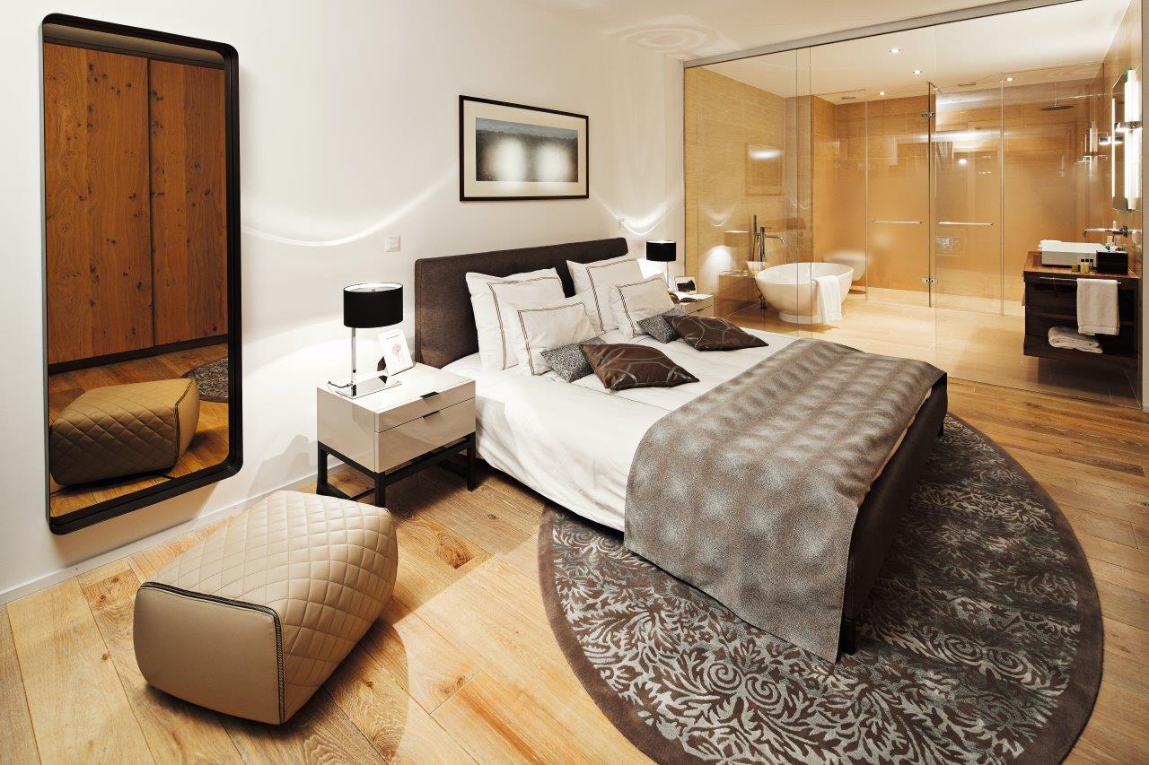 Ein Schlafzimmer mit einem großen Bett und einem runden Teppich