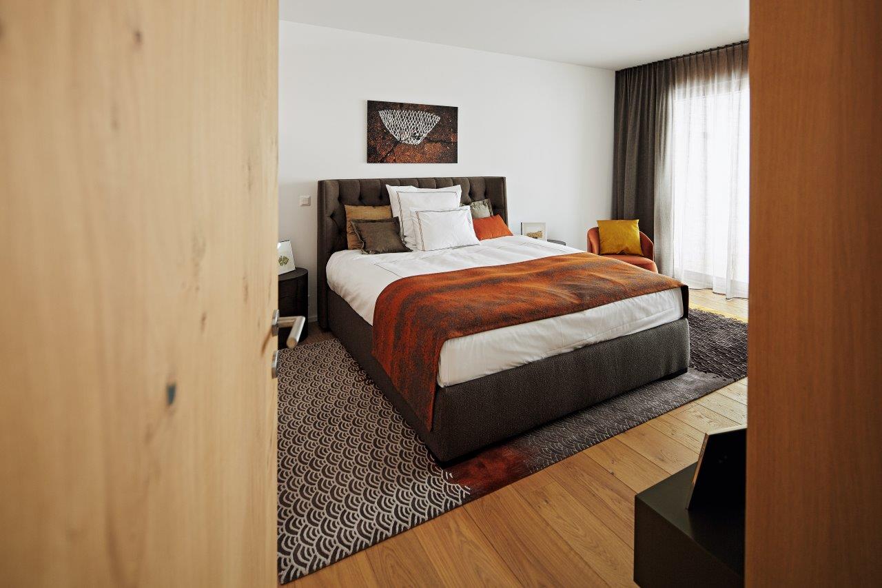 Ein Schlafzimmer mit einem großen Bett und einer Holztür