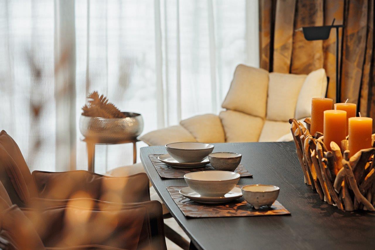 Ein Wohnzimmer mit einem Tisch mit Schüsseln und Kerzen darauf