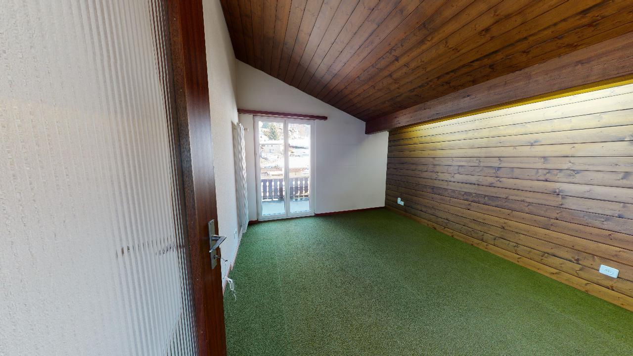 Ein leerer Raum mit einer Holzdecke und einem grünen Teppich