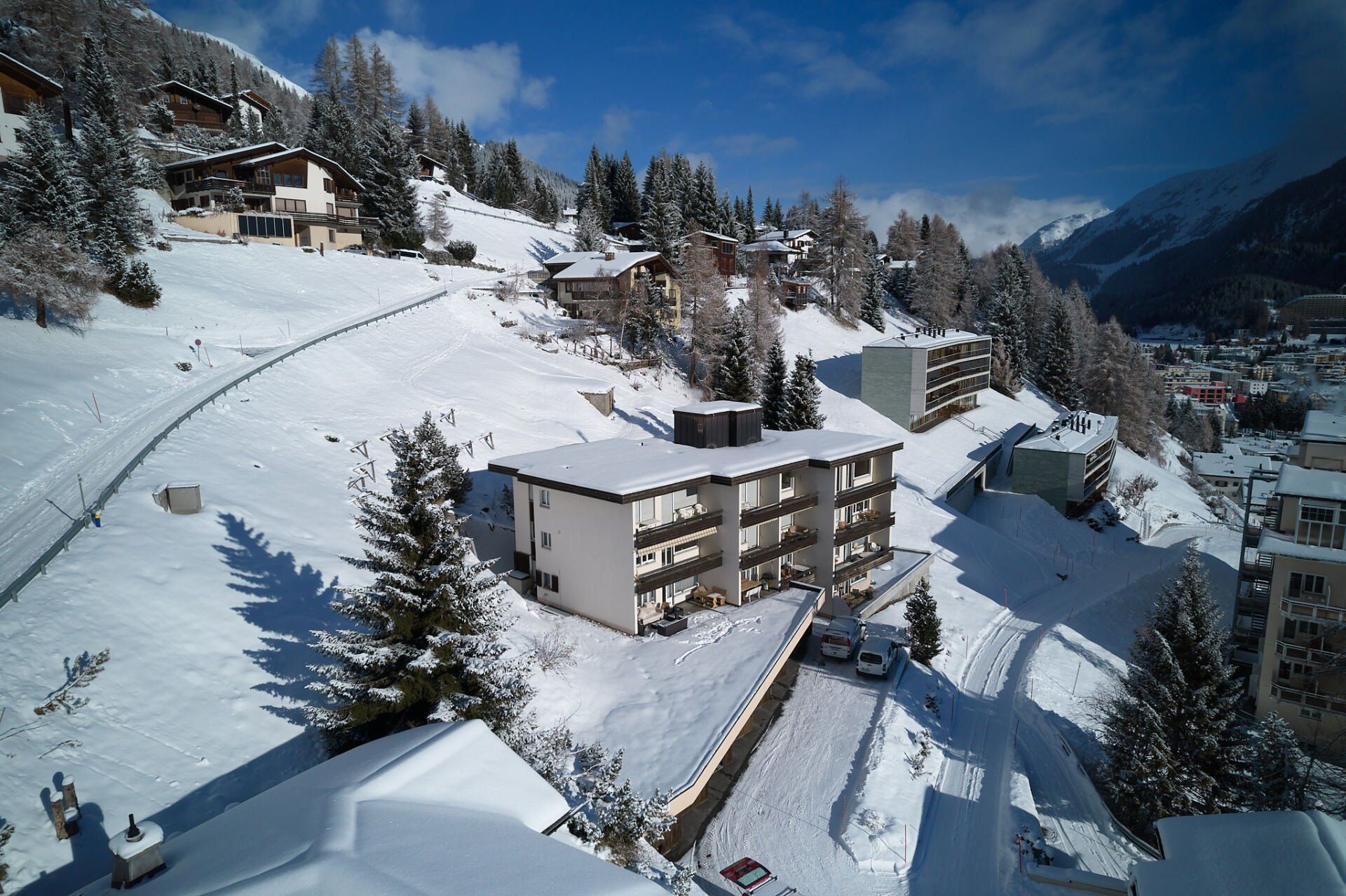 Eine Luftaufnahme einer verschneiten Landschaft mit einem Gebäude im Vordergrund