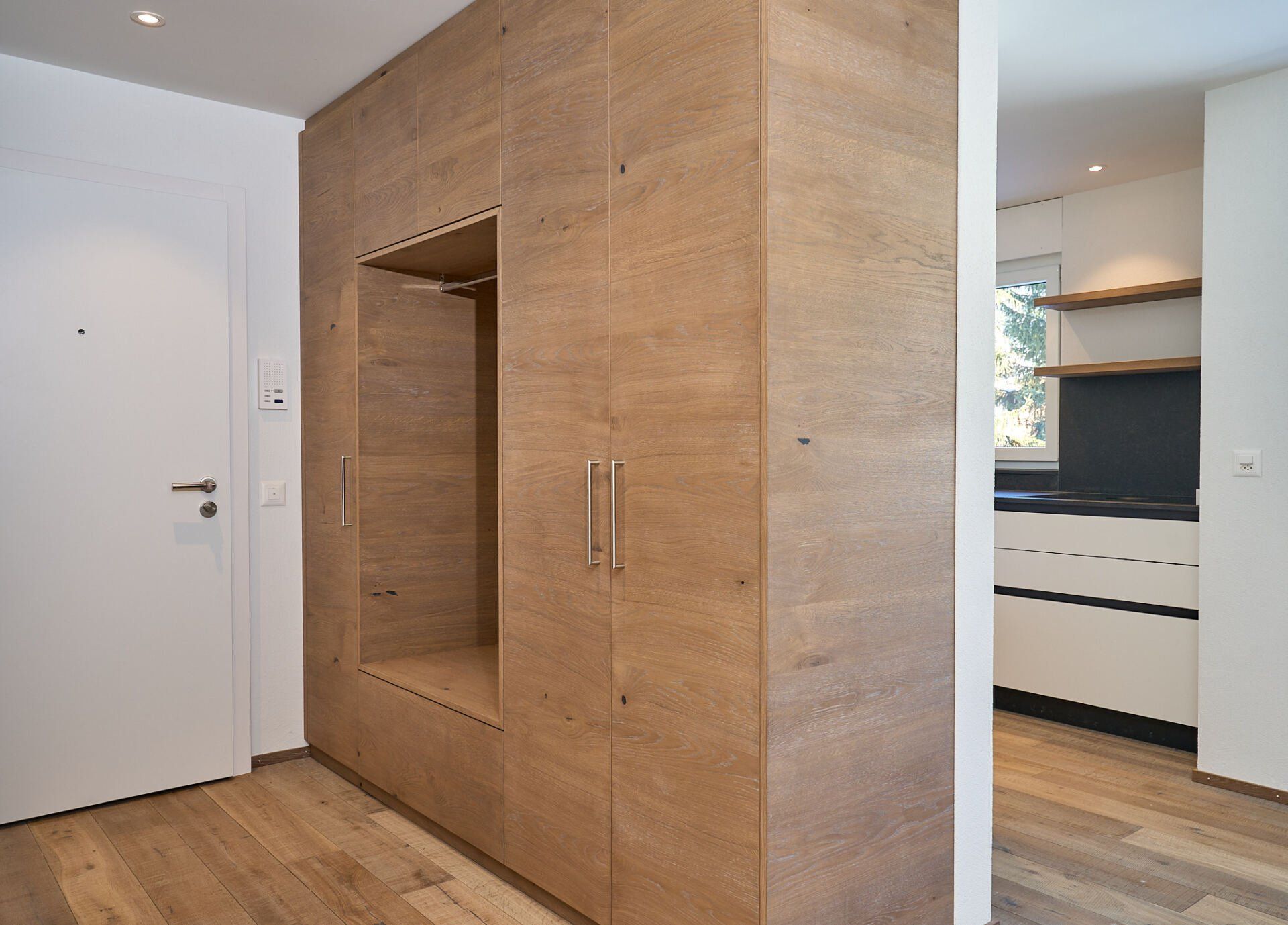 Ein Flur mit Holzschränken und einer weißen Tür