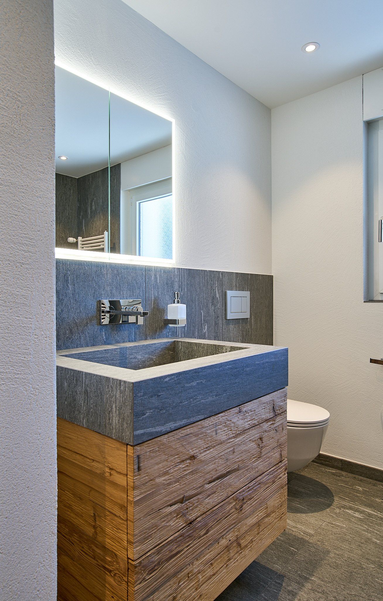 Ein Badezimmer mit Waschbecken, Toilette und Spiegel.