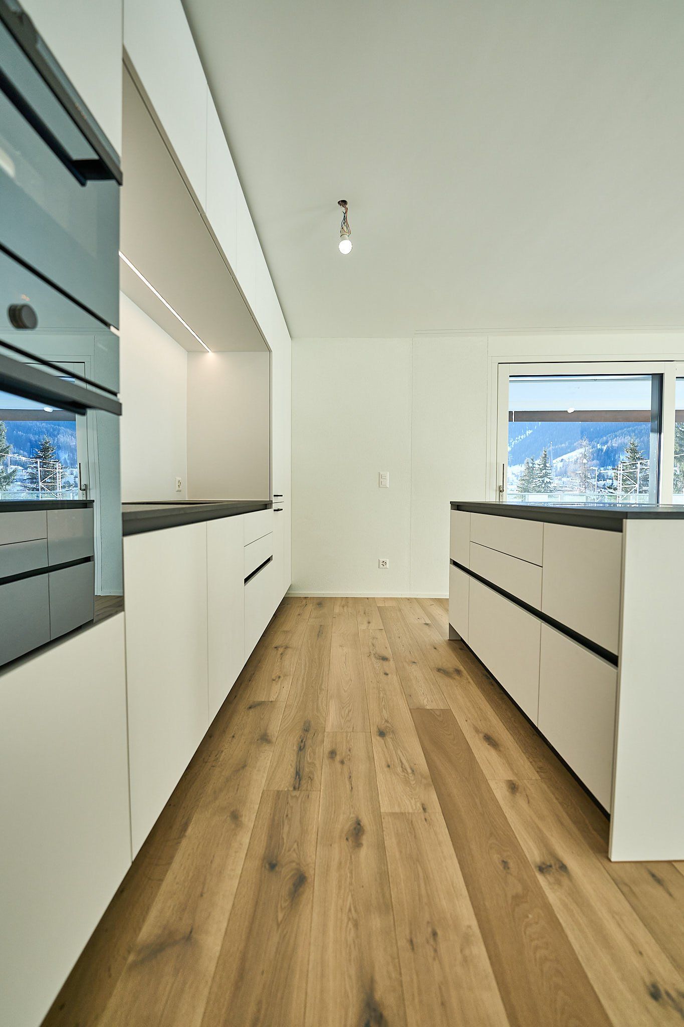 Eine Küche mit weißen Schränken und Holzböden