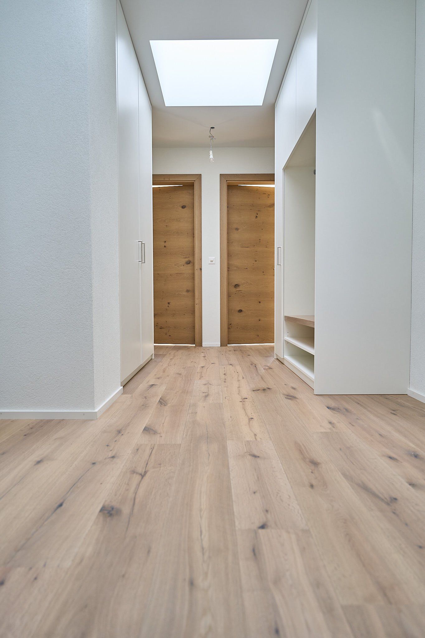 Ein Flur mit Holzboden und einem Oberlicht in der Decke