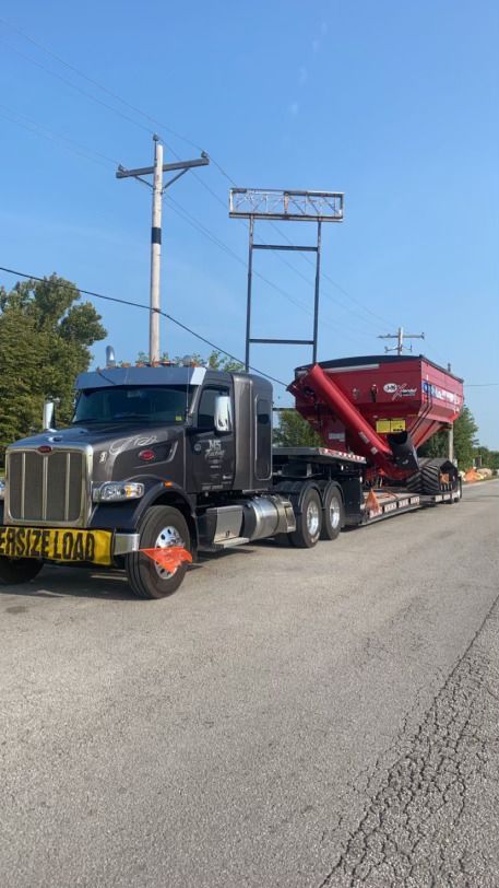 A semi truck is carrying a grain silo on the back of it