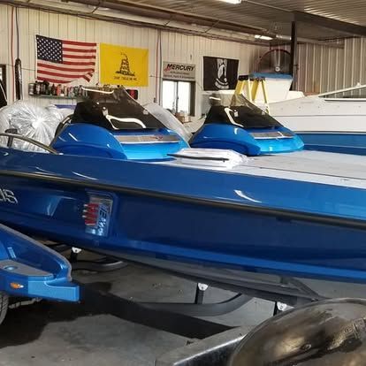 A row of blue boats are parked in a garage