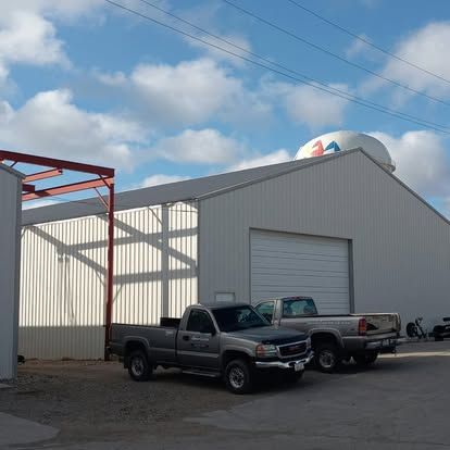Two pickup trucks are parked in front of a building