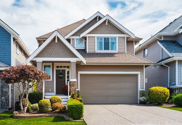 A large house with a garage and a driveway in front of it.