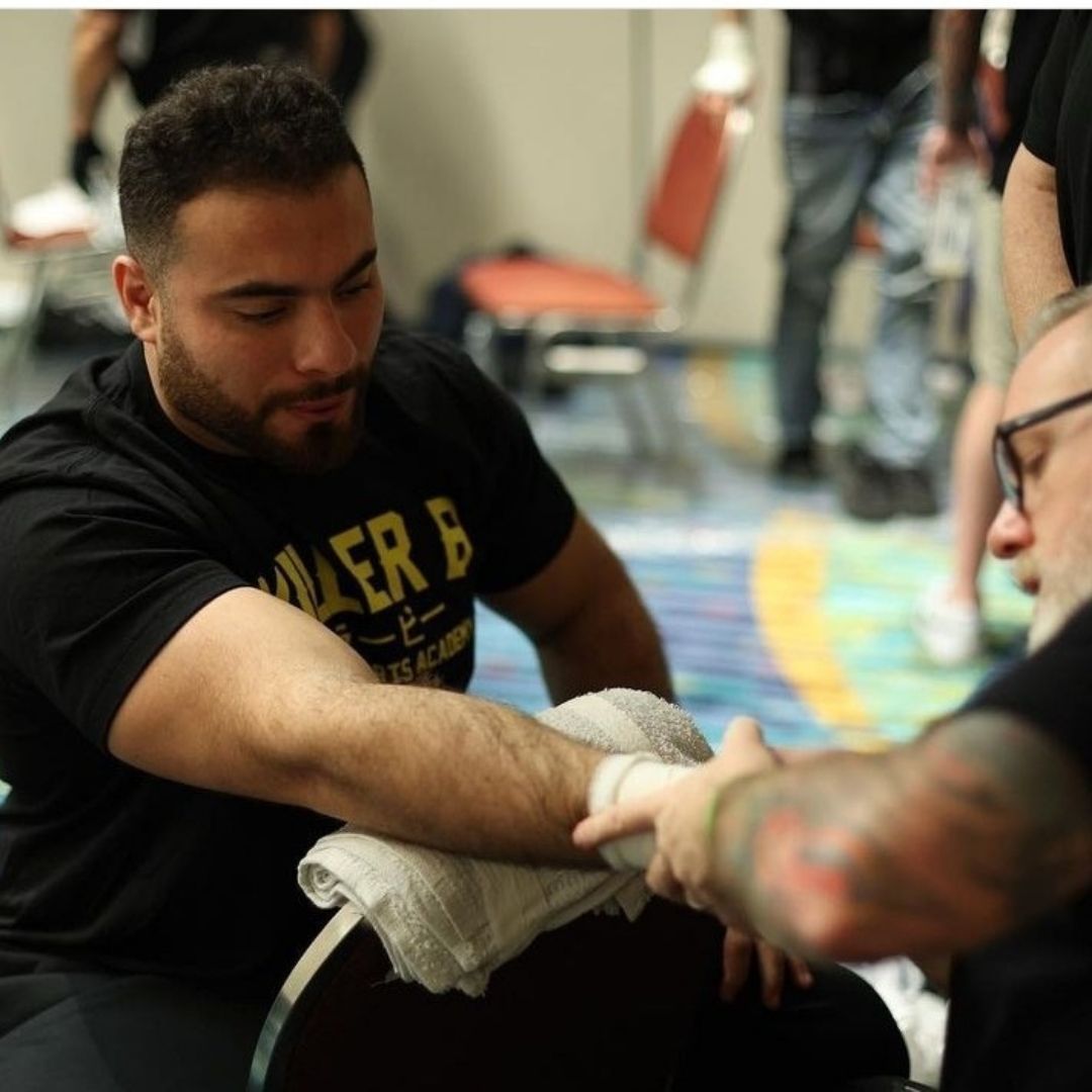 Adults practicing MMA pad drills at Killer B Combat Academy in Oakhurst, NJ for stress relief.