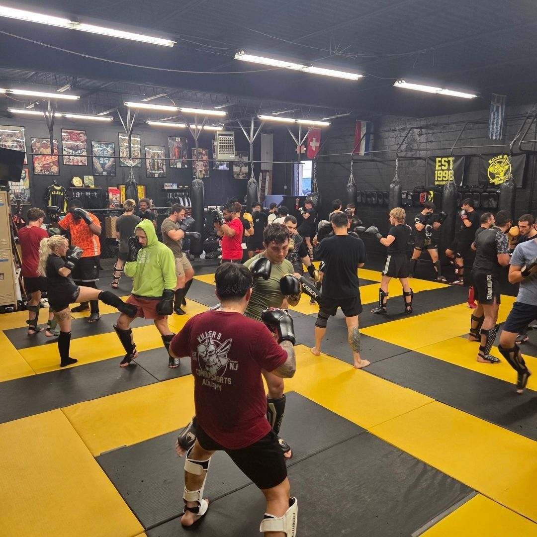 Adults practicing kickboxing combinations at Killer B Combat Academy in Oakhurst, NJ for fitness.