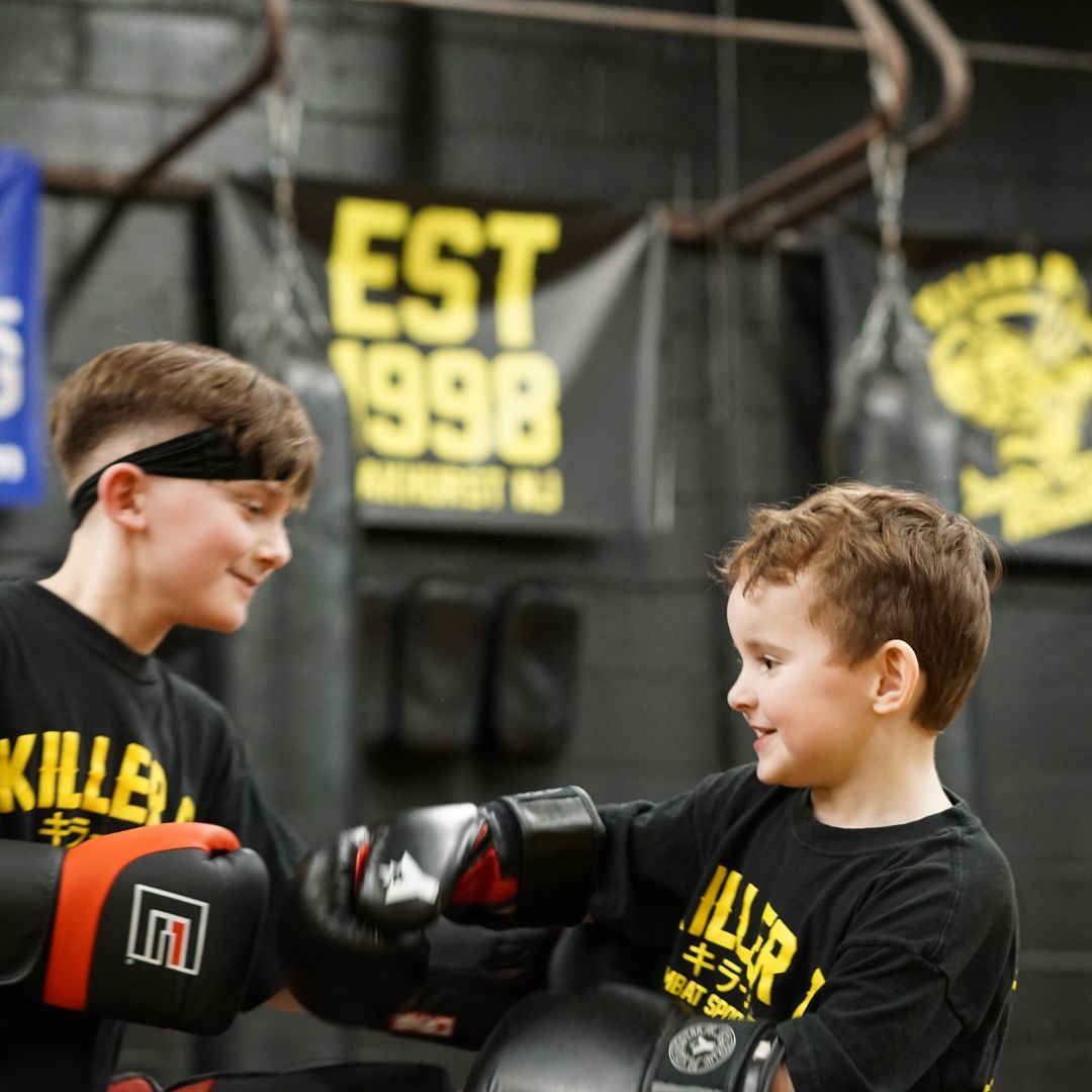 Kids practice partner drills at Killer B Combat Academy in Oakhurst, NJ, building confidence.