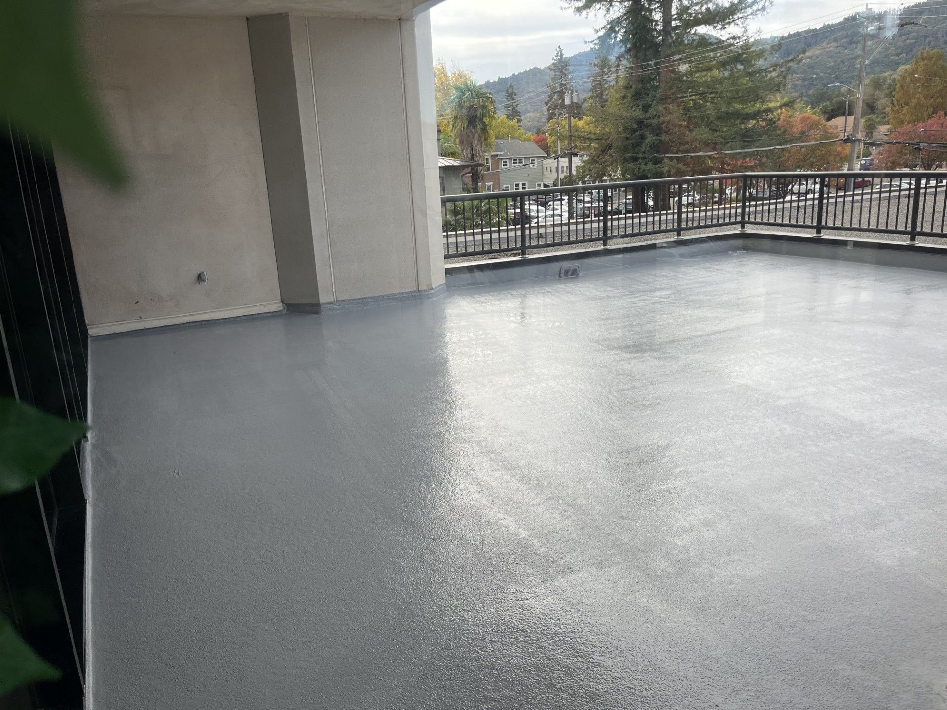 A person is cleaning a wooden deck with a broom.