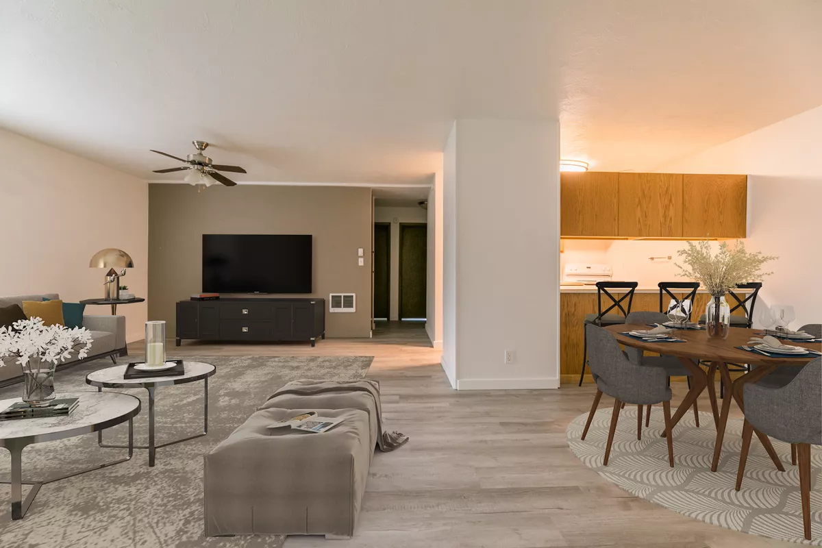 A living room with a couch , table , chairs and a flat screen tv.