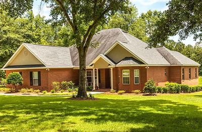 Home Roof Repair — Brick Colored Residential House in Northeast FL