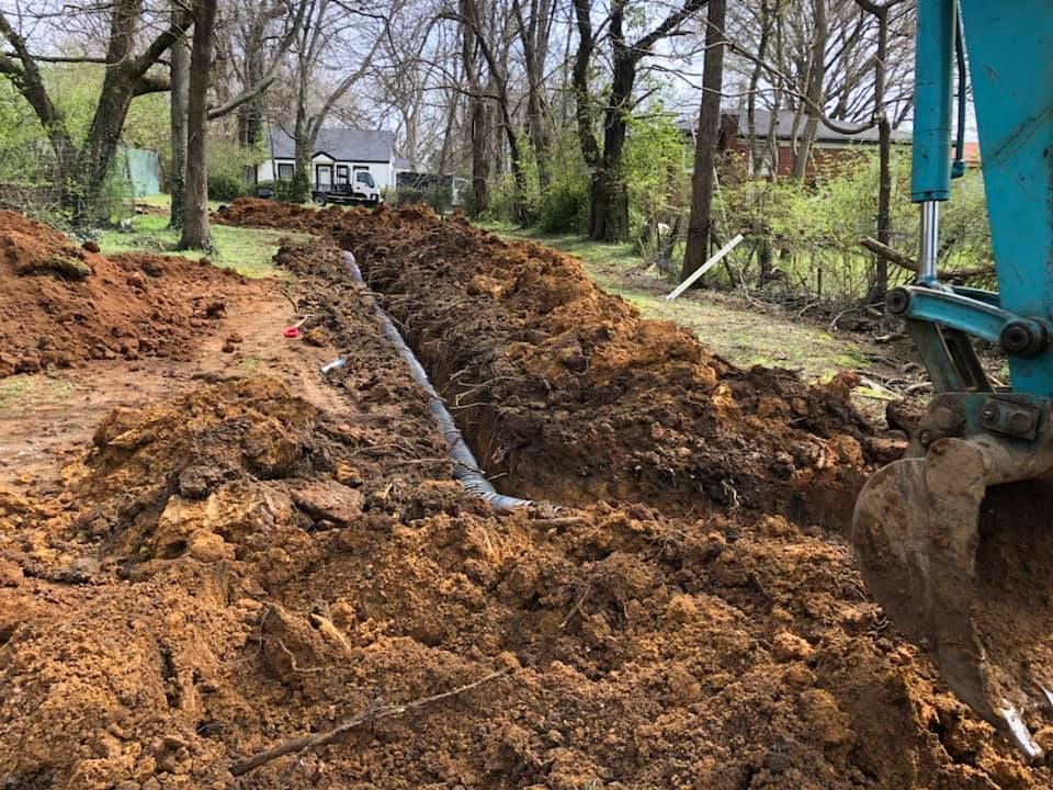 A large pile of dirt is being excavated in a yard.