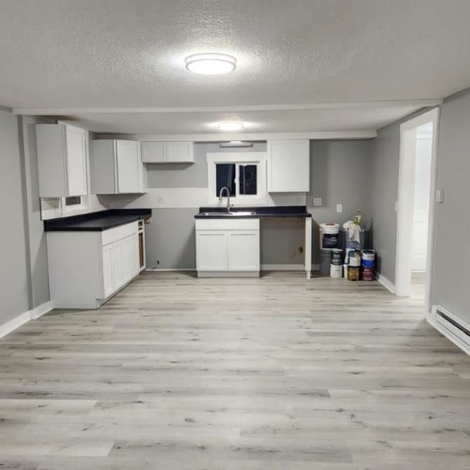 A man is measuring a wall with a tape measure.