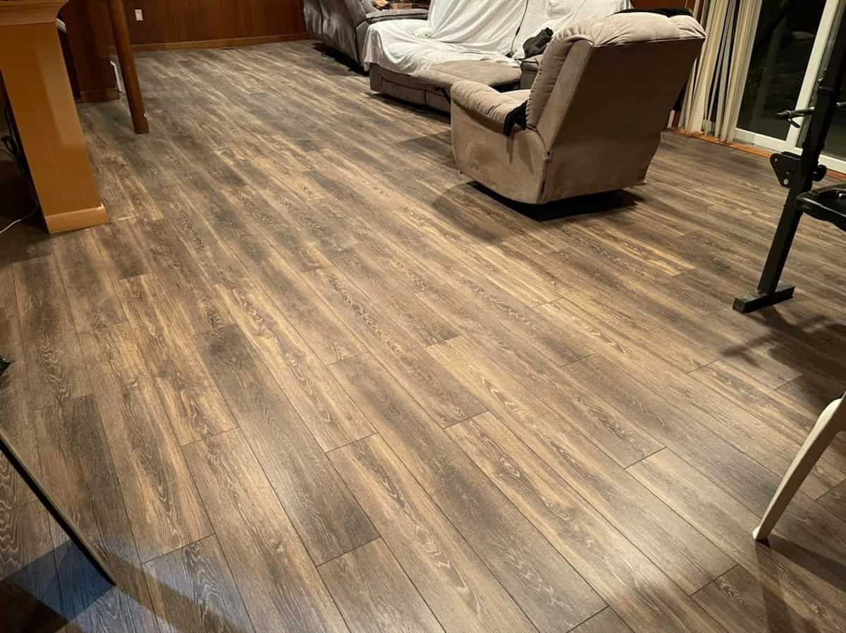 A man is using a spatula to remove a hole in a wall.