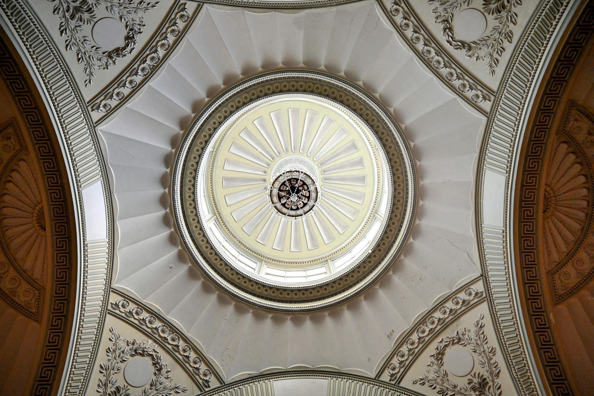 A man is measuring a wall with a tape measure.