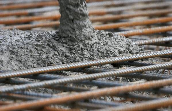 Calce vivo viene versato su una griglia di barre d'acciaio arrugginite per la costruzione.