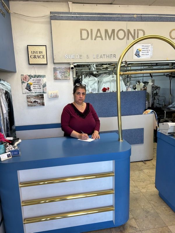 Woman at a dry cleaner's counter.