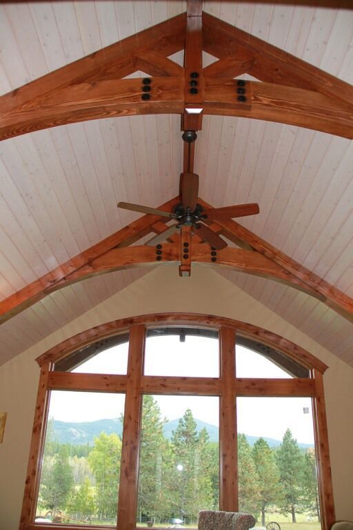 A living room with arched windows and a ceiling fan