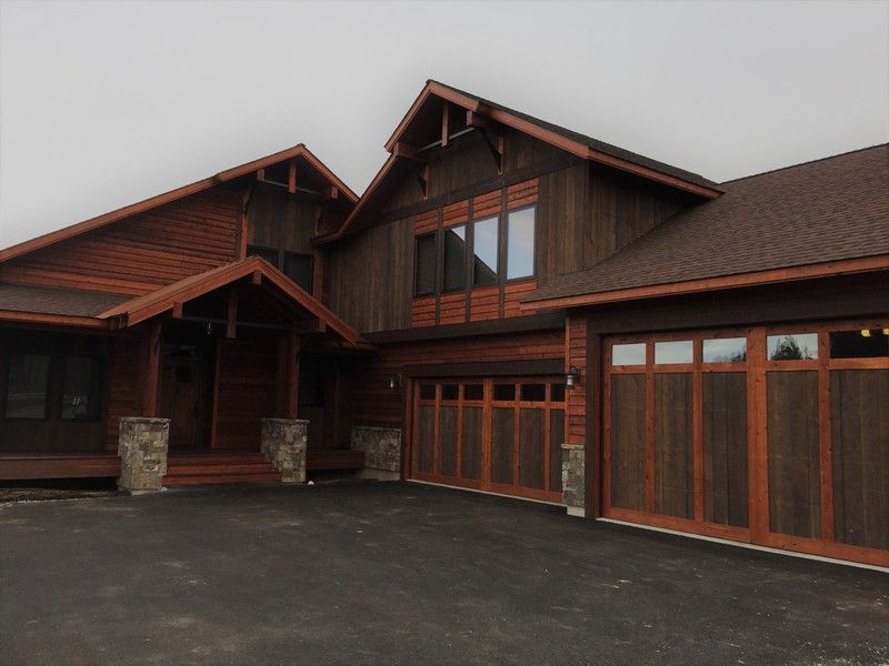 A large wooden house with a large garage door