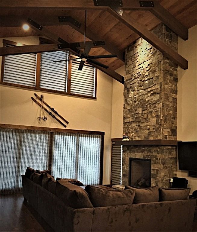 A living room with a stone fireplace and a couch