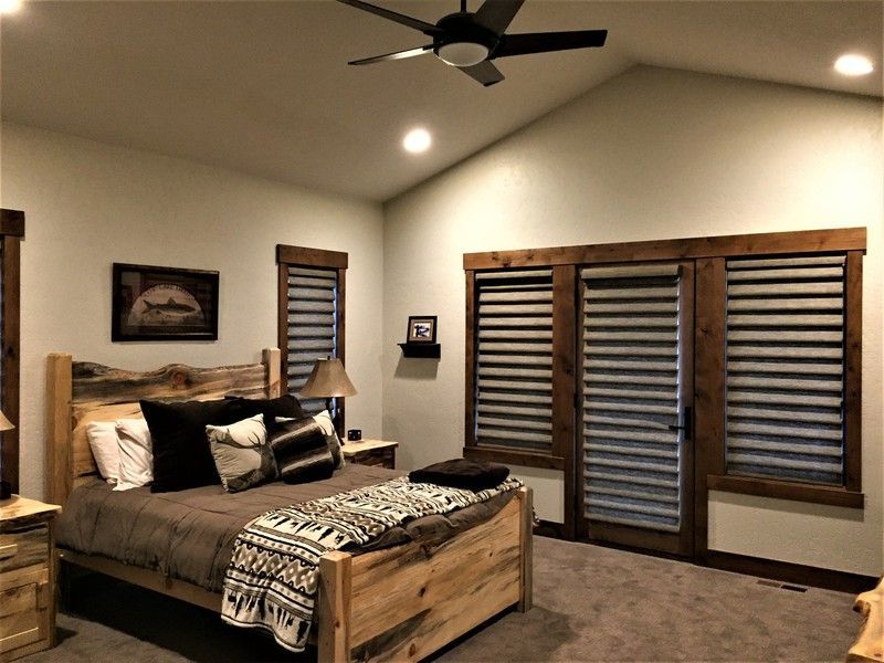 A bedroom with a bed and a ceiling fan