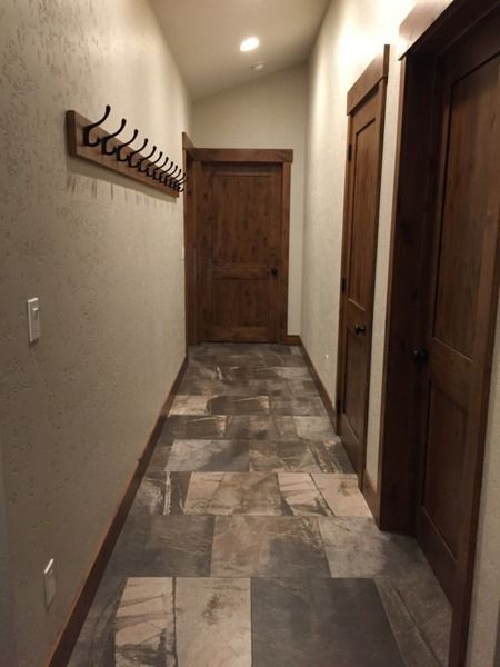 A hallway with a wooden door and hooks on the wall