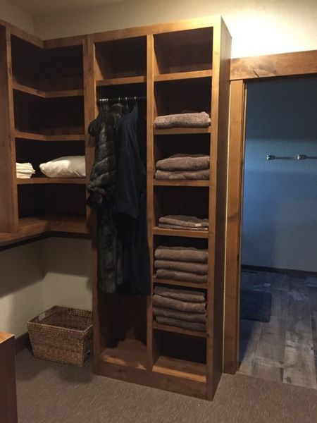 A closet with clothes and towels on shelves