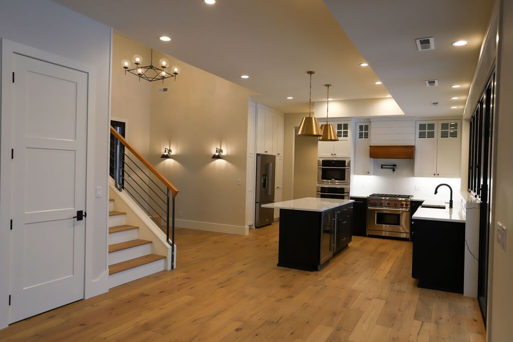 A kitchen with a large island and stairs leading up to it